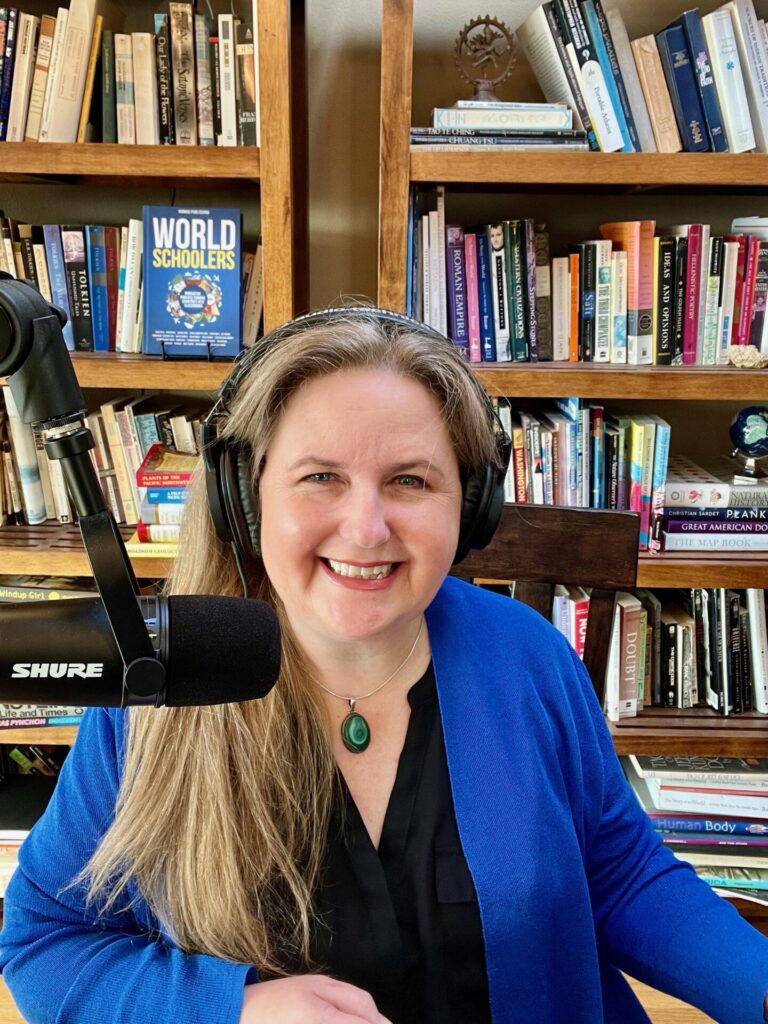 Erica Forrest, the author and travelpreneur behind a microphone and with headphones on in front of a bookshelf.