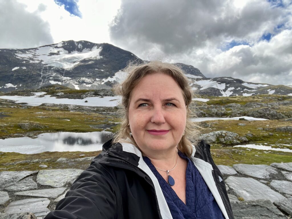 The author, Erica Forrest surrounded by glacial carved land, lakes, and glaciers in Norway.